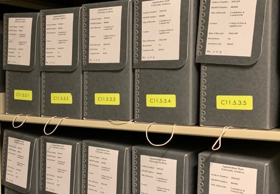 University Archives materials arranged in phase boxes on shelves